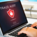 Fraud alert warning on the screen of a laptop computer