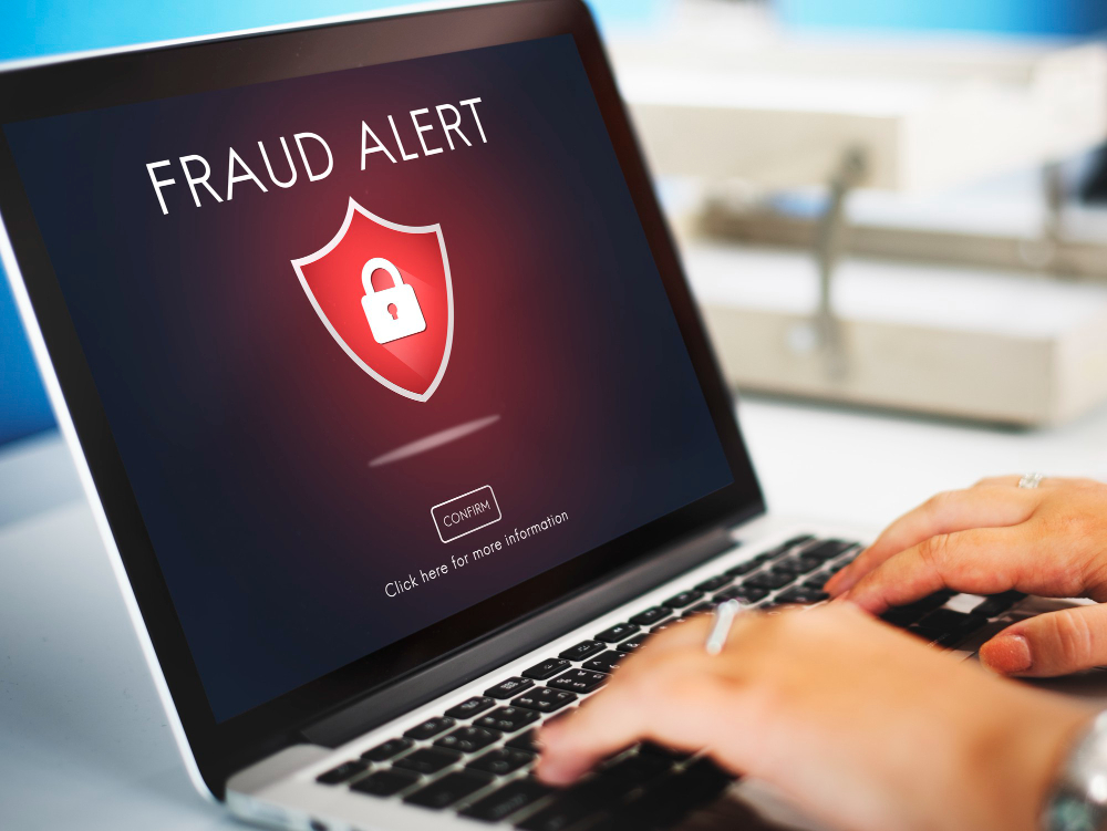 Fraud alert warning on the screen of a laptop computer